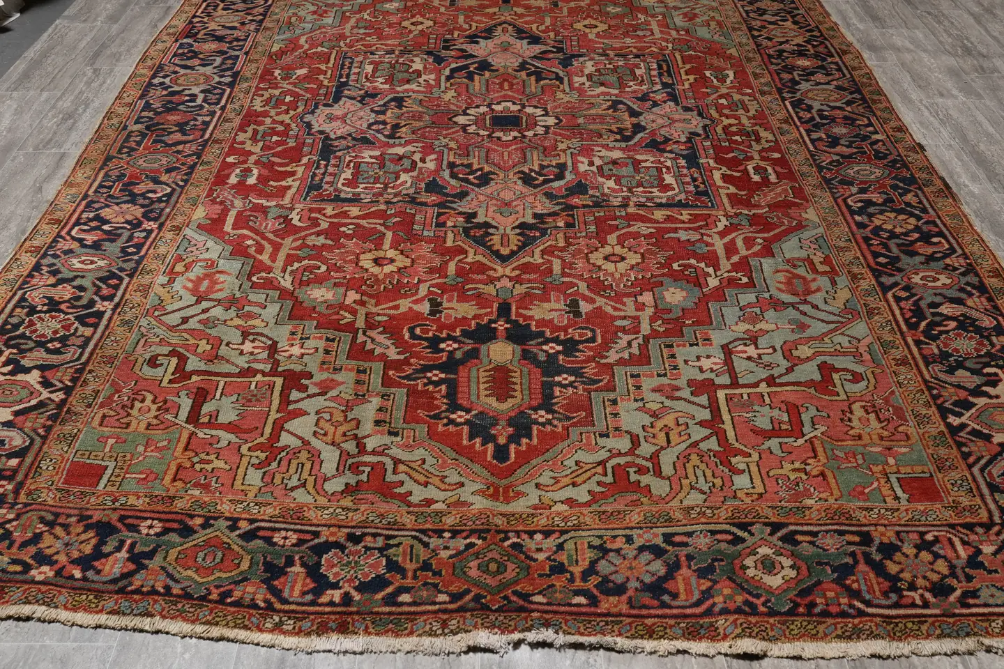 An antique Persian rug with a low, softened pile after a century of use