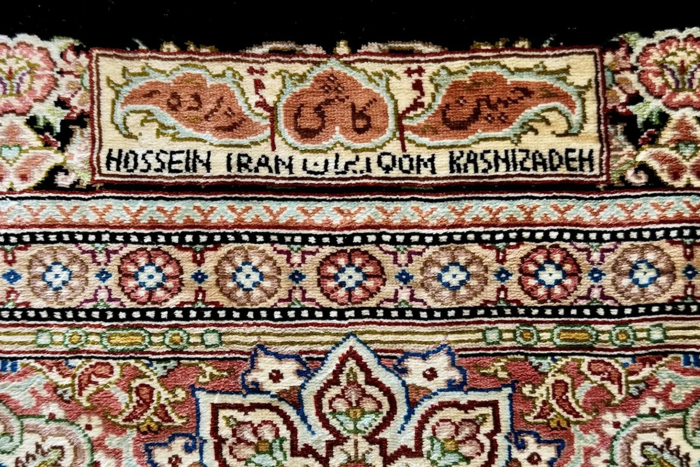 A woven cartouche carrying the name of the workshop that made the rug